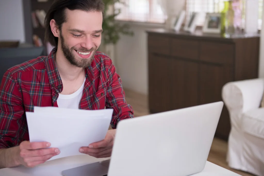 Extrato bancário, calculadora e notebook sobre mesa de reunião